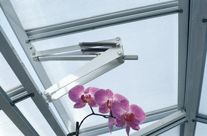 The Bayliss MK7 Orchid Solar Vent Opener is displayed on the roof of a greenhouse