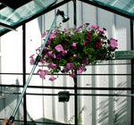 Telescoping Water Wand being used to water a hanging plant in a greenhouse